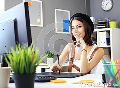 Young female designer using graphics tablet while working Stock Photo