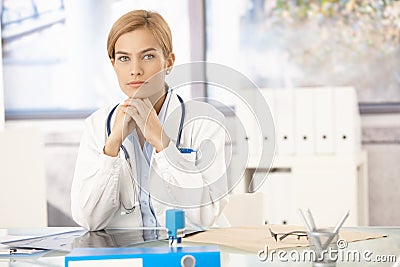 Young female doctor sitting at desk Stock Photo