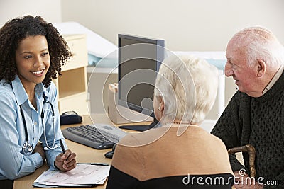 Young female Doctor talking to senior couple Stock Photo