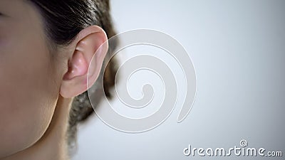 Young female ear closeup, useless rumors and disinformation, privacy intrusion Stock Photo