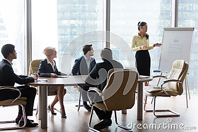 Young female employee present project on flipchart to colleagues Stock Photo