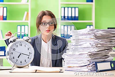 Young female employee very busy with ongoing paperwork in time m Stock Photo