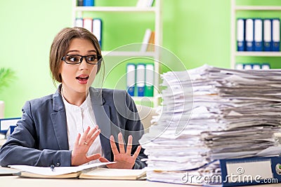 The young female employee very busy with ongoing paperwork Stock Photo