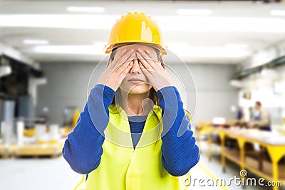 Young female engineer covering her eyes Stock Photo