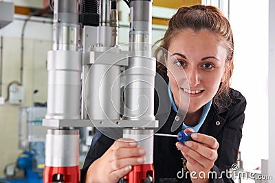 Young Female Engineer Working On Machine In Factory Stock Photo