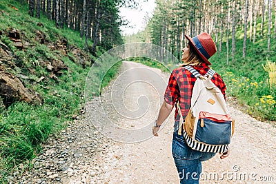 Young female explorer walking on mountain dirt road Stock Photo