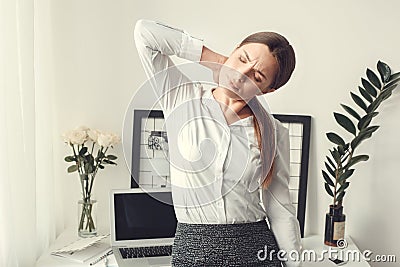 Young woman freelancer indoors home office concept formal style muscle pain Stock Photo