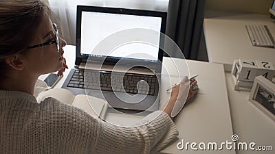 Young female freelancer works remotely. Setting up a workplace. Stock Photo