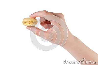 Young female hand holding yellow macaron isolated on white Stock Photo