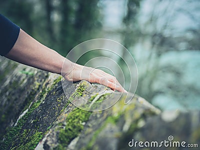 Female hand resting on stone wall Stock Photo