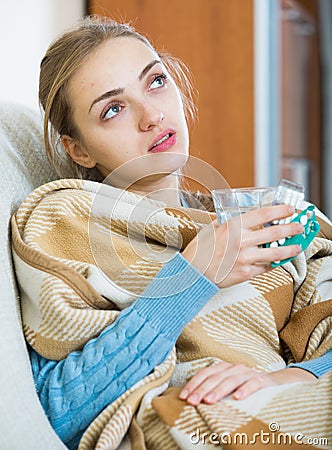 Young female having quinsy and fever and staying in couch Stock Photo