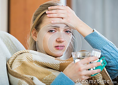 Young female having quinsy and fever and staying in couch Stock Photo