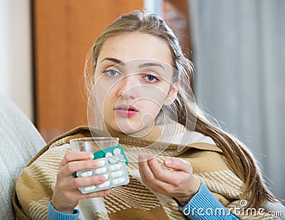 Young female having quinsy and fever and staying in couch Stock Photo