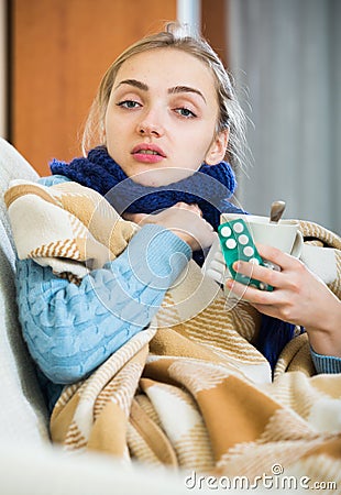 Young female having quinsy and fever and staying in couch Stock Photo