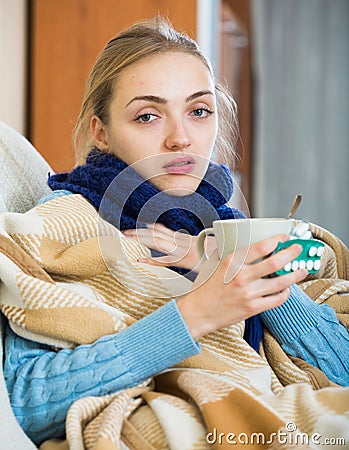 Young female having quinsy and fever and staying in couch Stock Photo