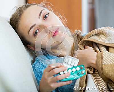 Young female having quinsy and fever and staying in couch Stock Photo