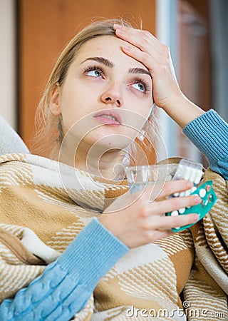 Young female having quinsy and fever and staying in couch Stock Photo