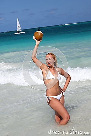 Young female holding coconut on tropical beach Stock Photo