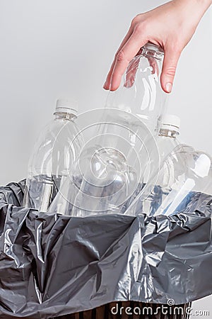 Young female housewife throws away empty plastic bottles Stock Photo