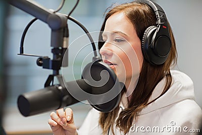 Radio Jockey Looking Away While Using Headphones And Microphone Stock Photo