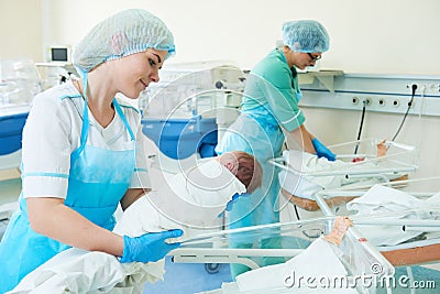 Young female nurse holding a newborn baby in hospital Stock Photo