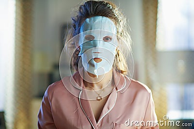 Young female applying sheet facial mask Stock Photo