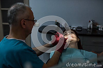 Young female patient with senior male dentist having a dental treatment. Stock Photo