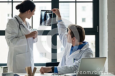 Young female physician asking for advice from her experienced male colleague Stock Photo
