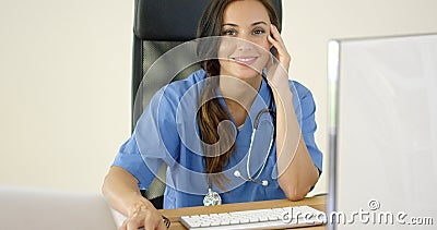 Young female physician places one hand on her face Stock Photo