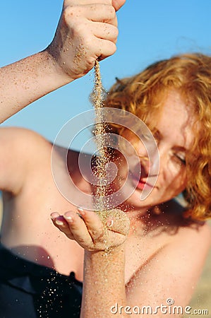 Young female pouring sand hand to hand Stock Photo