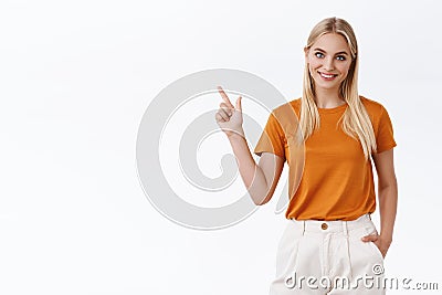 Young female professional pointing chart. Attractive blond girl with blue eyes, tattoos, hold hand in pants carefree Stock Photo