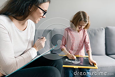 Young female psychologist talking with patient child girl in office. Mental health of children Stock Photo