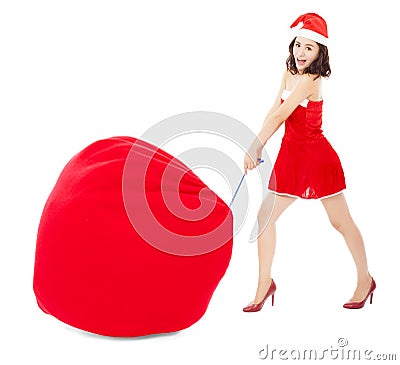 Young female pull a heavy gift bag with Christmas suit Stock Photo