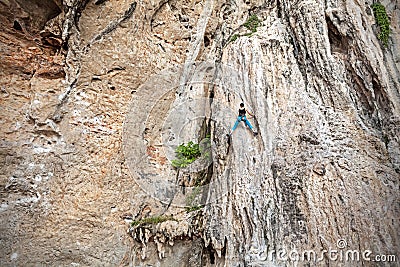 Young female rock climber on incredible wall. Stock Photo