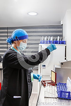 Young female scientist preparing slides for karyotype and fluorescence in situ hybridization at the laboratory Stock Photo