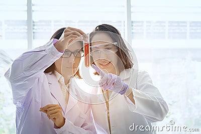 Young female scientist standing with techer in lab worker making Stock Photo