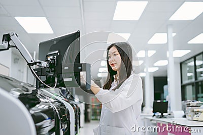 young scientist working with automation blood analyzer report in medical laboratory Stock Photo