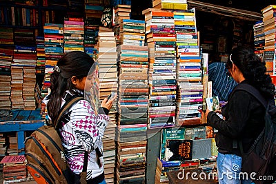 Young female student choose the book on the street market Editorial Stock Photo