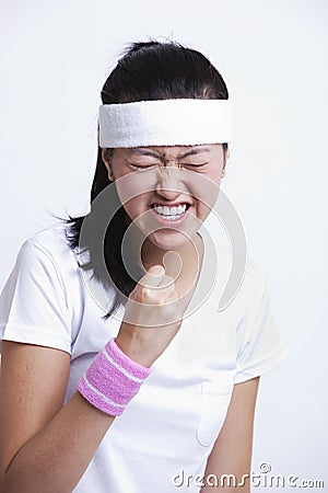 Young female tennis player celebrating success against white background Stock Photo