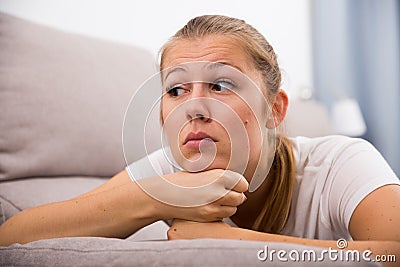 Young female is thoughtful and bored alone Stock Photo