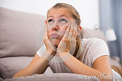 Young female is thoughtful and bored alone Stock Photo