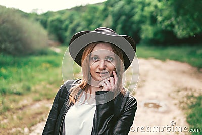Young female tourist with a pink backpack and leather cowboy style hat looking at the distance. Copy space for your text. Stock Photo