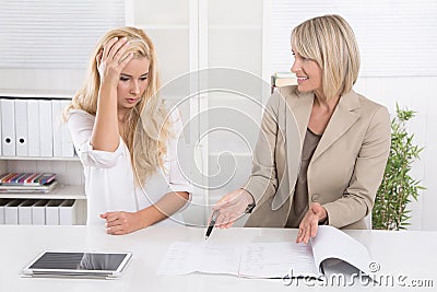 Young female trainee had made an error at work and her boss criticize her. Stock Photo