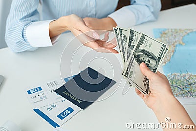 Young female travel agent consultant in tour agency with a customer cash payment close-up Stock Photo