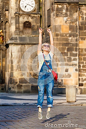 Young female traveler jumping with joy at the Old Town Square in Prague. Stock Photo