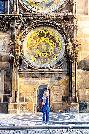 Young female traveler refers to the astronomical clock in the Old Town Hall. Prague Stock Photo