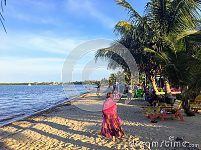 A young female vacationer goes for a peaceful stroll along the sandy beaches of beautiful Placencia, Belize Editorial Stock Photo