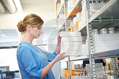 Young female worker holding boxes in warehouse Stock Photo