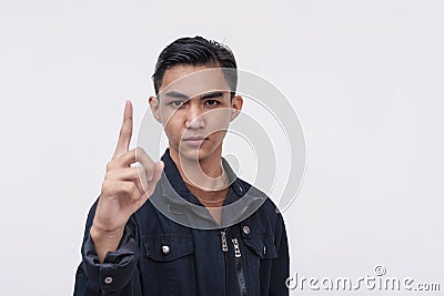 A young Filipino man gives a stern warning. A no-nonsense guy confronting and reprimanding someone with a finger gesture. Isolated Stock Photo