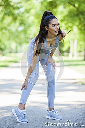Young fit beautiful girl got calf injury during outdoor exercise Stock Photo